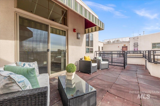 view of patio with outdoor lounge area and a balcony