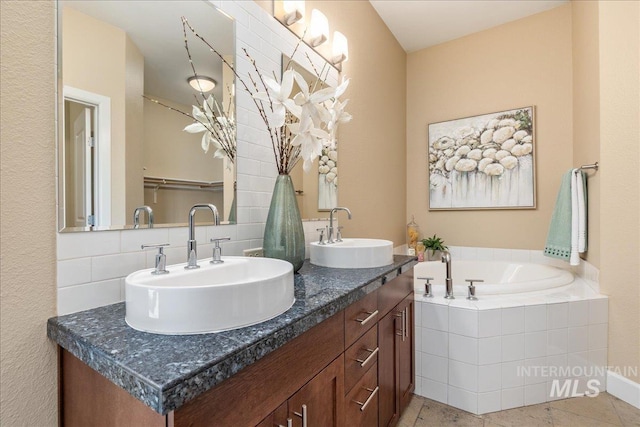 full bath with double vanity, a garden tub, a sink, and tile patterned floors