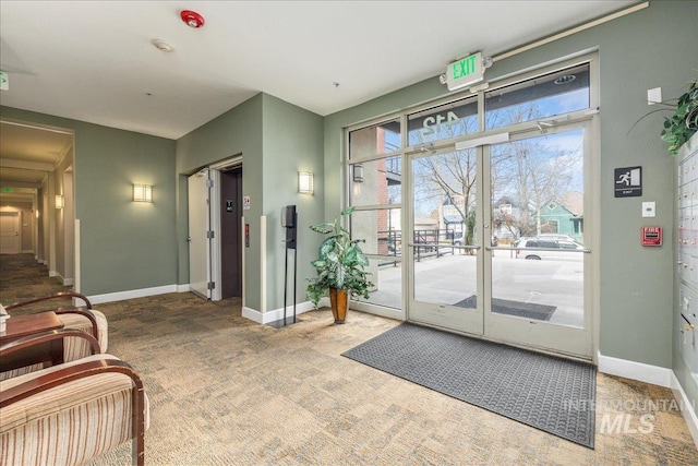 doorway to outside with carpet flooring and baseboards