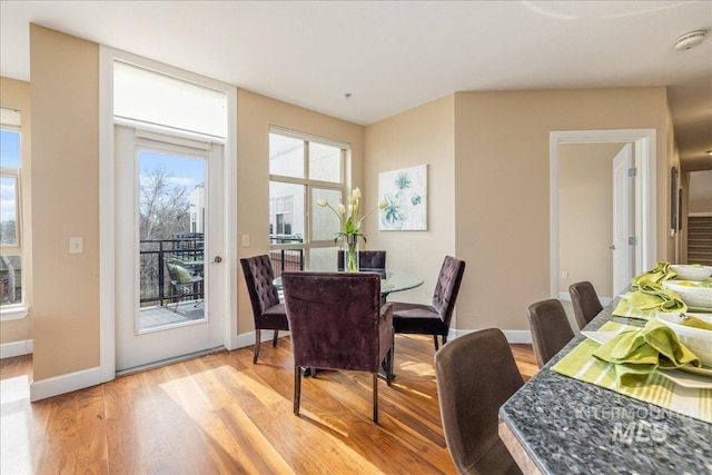 dining room featuring light wood finished floors and baseboards