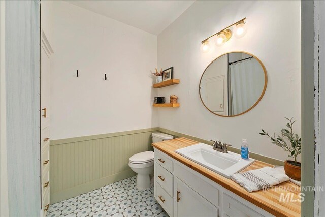 609 10th Ave S, Nampa, ID 83651 - bathroom with tile patterned floors, vanity, toilet, and wainscoting