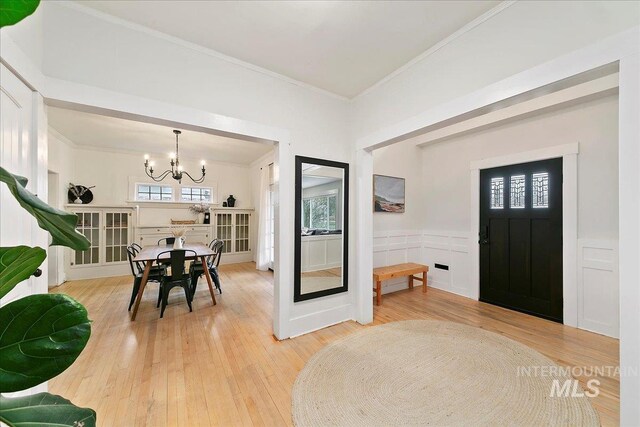 609 10th Ave S, Nampa, ID 83651 - entryway with crown molding, hardwood / wood-style flooring, a notable chandelier, and wainscoting