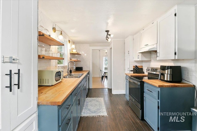609 10th Ave S, Nampa, ID 83651 - kitchen featuring wood counters, blue cabinetry, white microwave, and stainless steel electric range