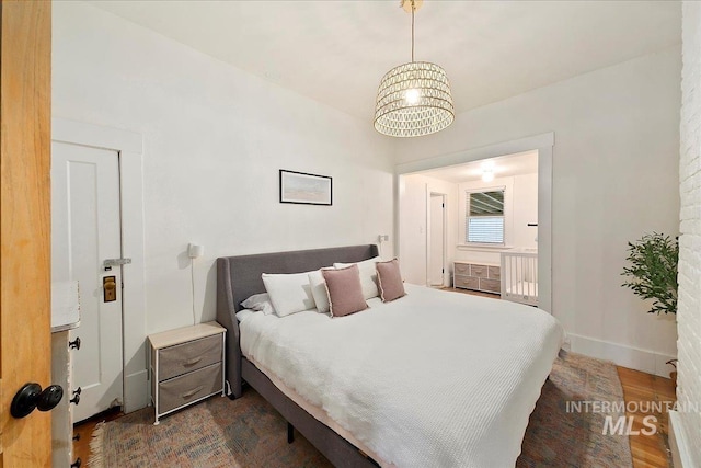 609 10th Ave S, Nampa, ID 83651 - bedroom featuring baseboards, dark wood-style floors, and a notable chandelier