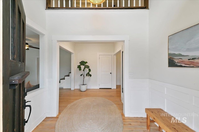 609 10th Ave S, Nampa, ID 83651 - foyer with light wood finished floors, stairs, a ceiling fan, and a wainscoted wall