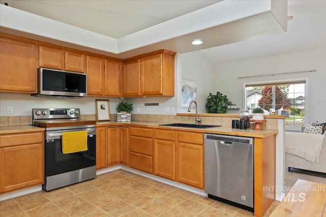 80 Cobblestone Ct, Middleton, ID 83644 - kitchen with appliances with stainless steel finishes, a peninsula, a sink, recessed lighting, and brown cabinetry