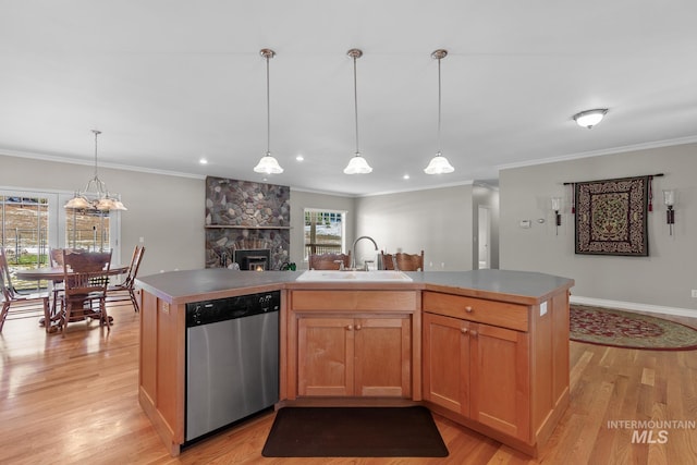 828 W Fork Eagle Creek Rd, Wallace, ID 83873 - kitchen featuring dishwasher, light wood-style floors, ornamental molding, a stone fireplace, and a center island with sink