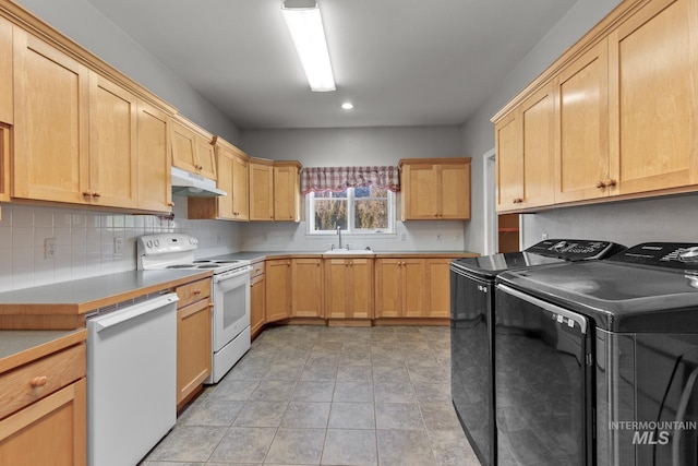 828 W Fork Eagle Creek Rd, Wallace, ID 83873 - kitchen with white appliances, under cabinet range hood, washer and clothes dryer, light brown cabinets, and backsplash