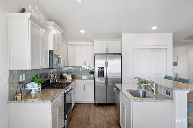 kitchen with white cabinetry, stainless steel appliances, sink, tasteful backsplash, and dark hardwood / wood-style floors