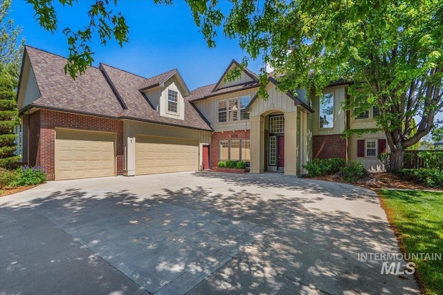 view of front of property featuring driveway, brick siding, and a garage