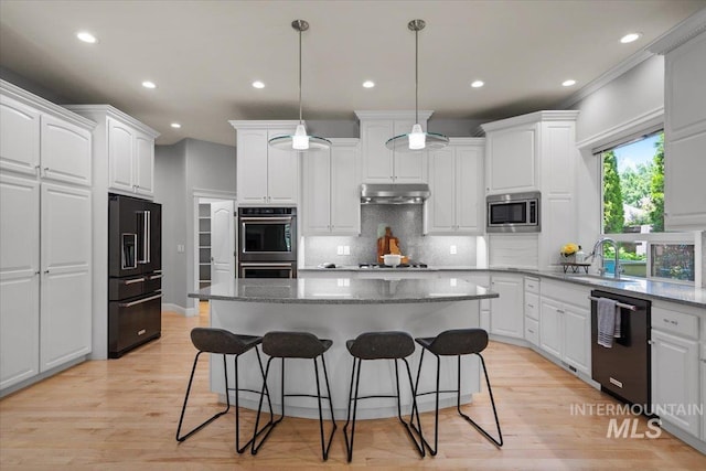 kitchen featuring black appliances, a sink, under cabinet range hood, white cabinetry, and recessed lighting