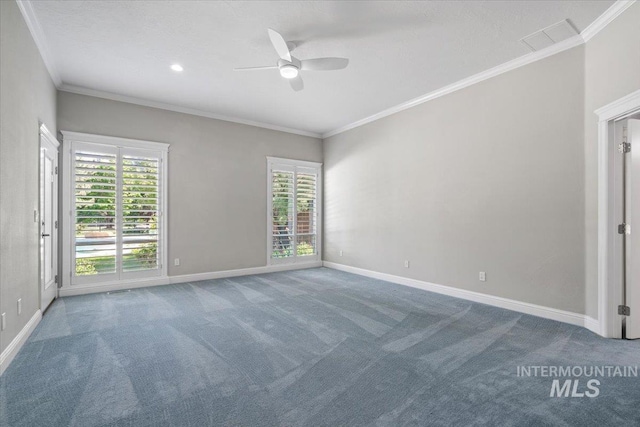 carpeted empty room with a ceiling fan, baseboards, and crown molding