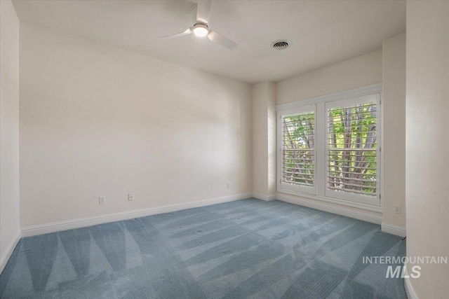 carpeted spare room with a ceiling fan and baseboards