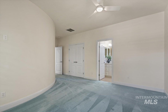 spare room featuring light carpet, baseboards, and a ceiling fan