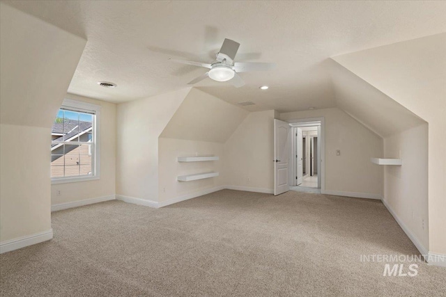 bonus room with carpet, lofted ceiling, baseboards, and ceiling fan