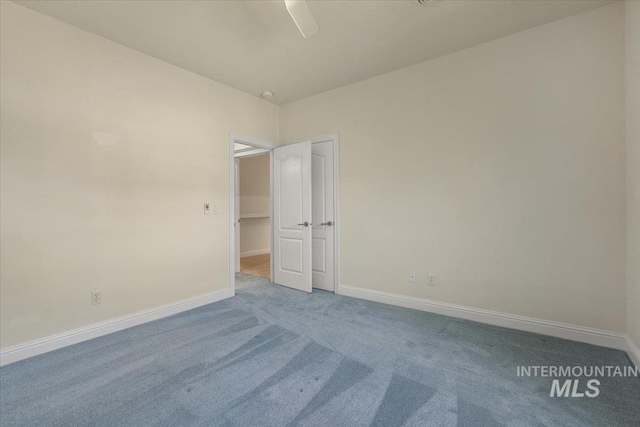 unfurnished room with carpet floors, baseboards, and ceiling fan