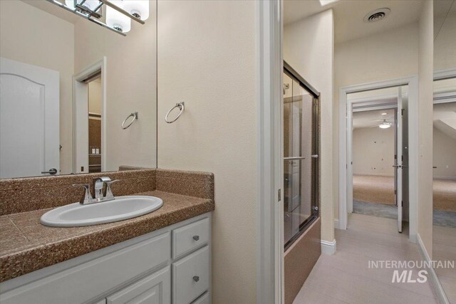 full bathroom with tile patterned floors, vanity, and combined bath / shower with glass door