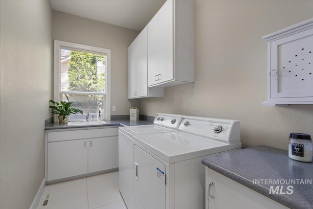 laundry room with cabinet space, washing machine and clothes dryer, and light tile patterned floors