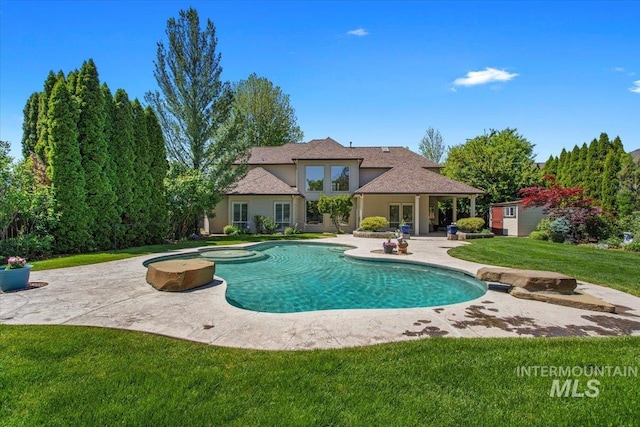 swimming pool featuring a patio area, a lawn, and french doors