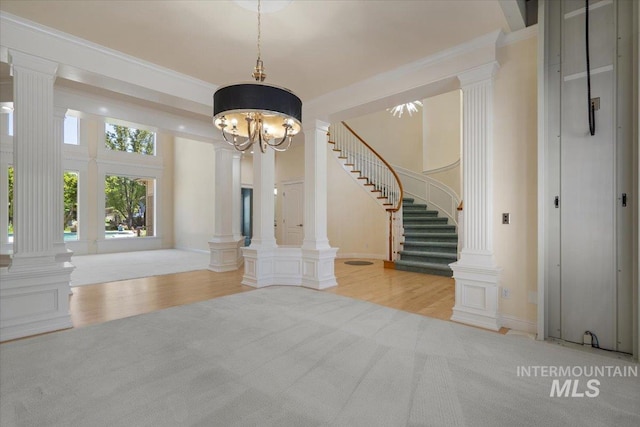 unfurnished dining area featuring decorative columns, stairway, light wood finished floors, a chandelier, and light carpet