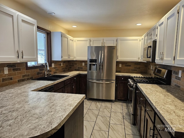 kitchen featuring marble finish floor, stainless steel appliances, a sink, and light countertops