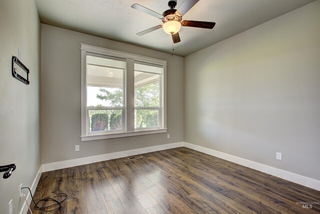 empty room with ceiling fan and dark wood-type flooring