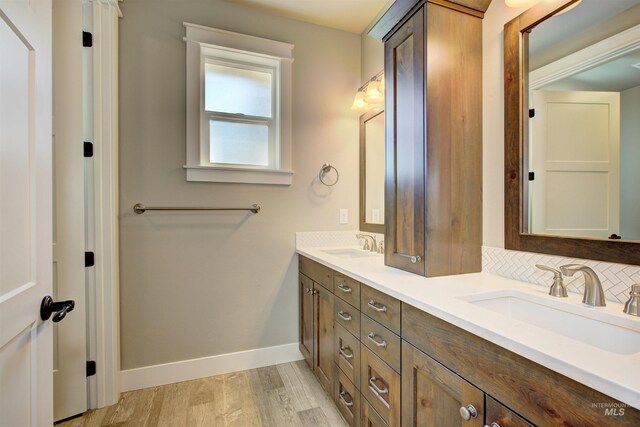 bathroom featuring hardwood / wood-style floors, tasteful backsplash, and double vanity