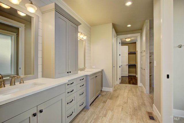 bathroom featuring hardwood / wood-style floors and double sink vanity