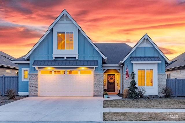 view of front of property with board and batten siding, concrete driveway, and fence