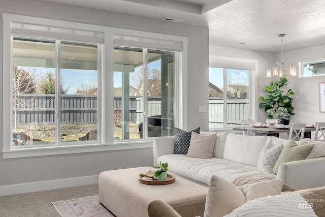 living room with plenty of natural light, baseboards, visible vents, and carpet floors