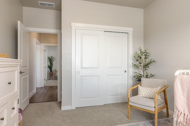 living area featuring visible vents and carpet floors