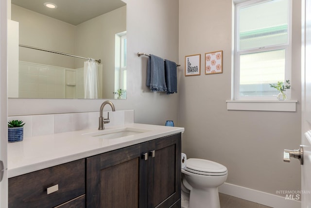 bathroom with vanity, a shower with shower curtain, baseboards, tile patterned flooring, and toilet