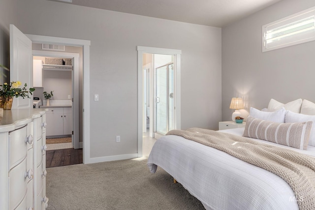 carpeted bedroom featuring visible vents, baseboards, and connected bathroom