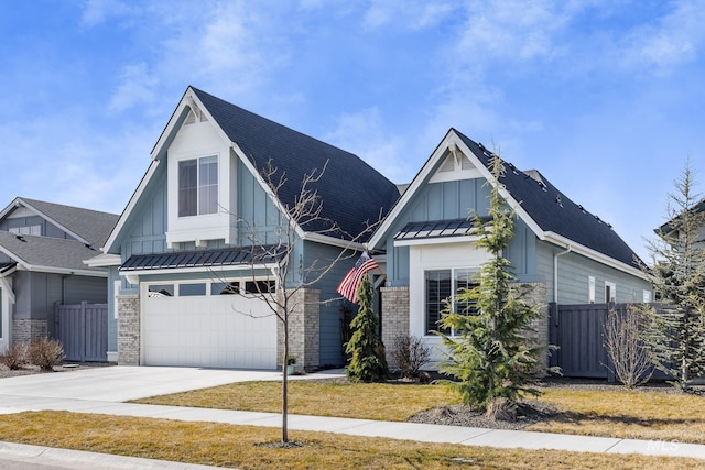 modern farmhouse style home with board and batten siding, concrete driveway, a standing seam roof, and fence