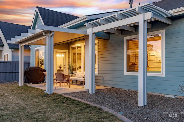 exterior space with a lawn, a pergola, a patio, fence, and roof with shingles