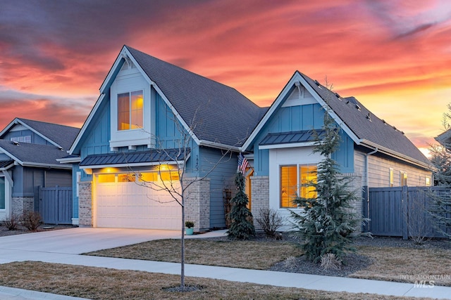 view of front facade featuring board and batten siding, fence, a garage, driveway, and a standing seam roof