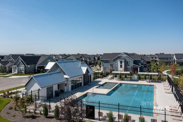 community pool featuring a residential view, a patio, and fence