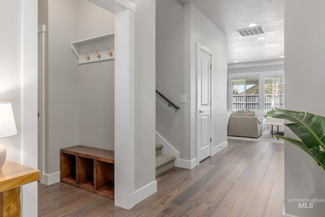 corridor featuring stairway, wood finished floors, visible vents, baseboards, and recessed lighting