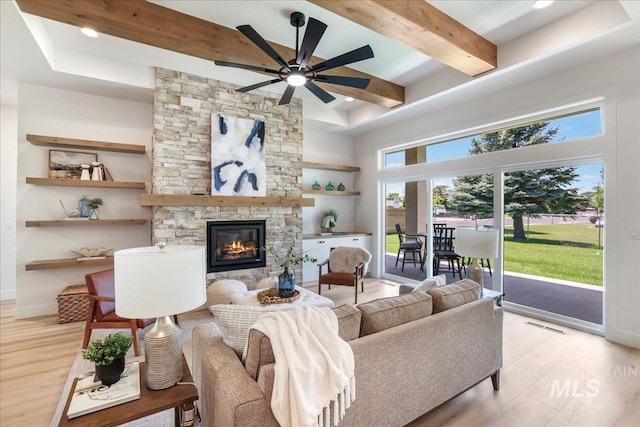 505 Stonehedge Loop, Twin Falls, ID 83301 - living area featuring beamed ceiling, light wood-style floors, a high ceiling, a stone fireplace, and a ceiling fan