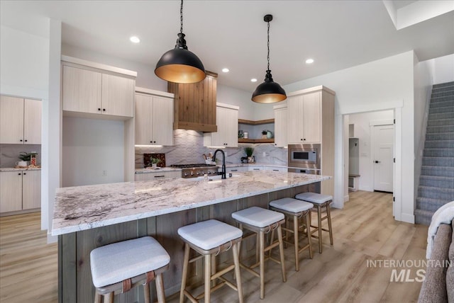 505 Stonehedge Loop, Twin Falls, ID 83301 - kitchen featuring stainless steel microwave, decorative backsplash, light wood-style floors, and recessed lighting