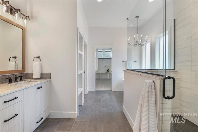 505 Stonehedge Loop, Twin Falls, ID 83301 - bathroom with a chandelier, a shower stall, vanity, tasteful backsplash, and a spacious closet