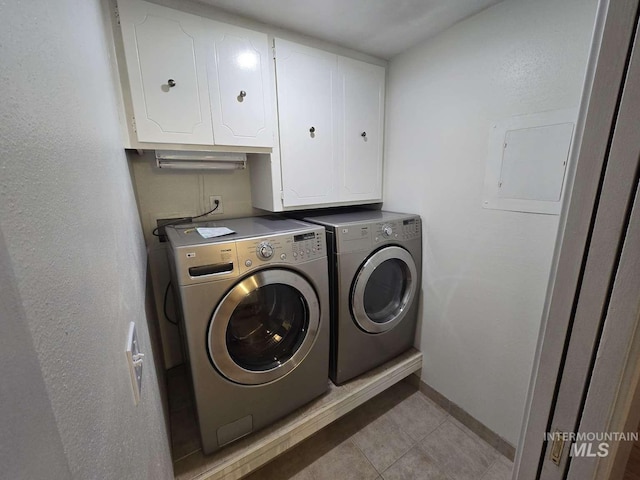 laundry area with light tile patterned flooring, cabinets, and washing machine and dryer