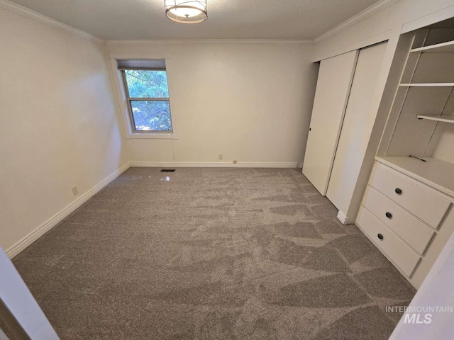 unfurnished bedroom featuring crown molding, a closet, and carpet flooring