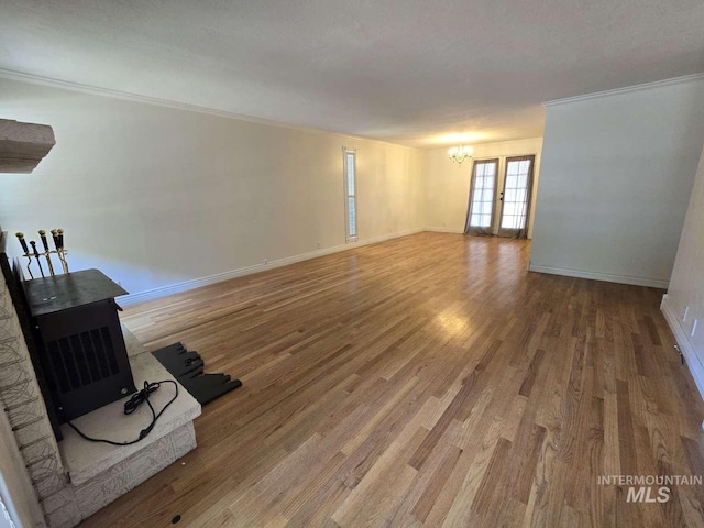 empty room featuring hardwood / wood-style flooring, ornamental molding, and a chandelier