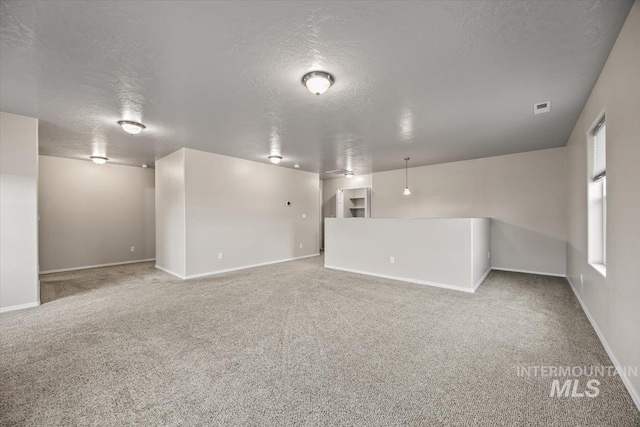 spare room with carpet floors and a textured ceiling