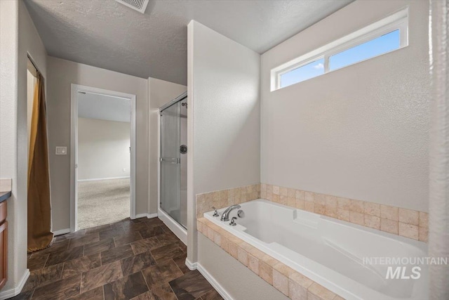 bathroom with vanity, independent shower and bath, and a textured ceiling