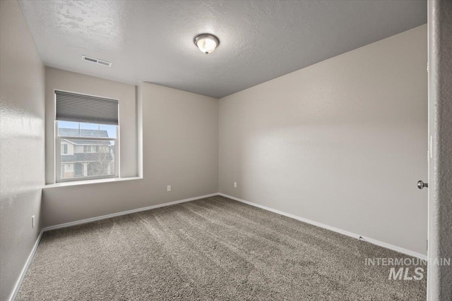 carpeted empty room with a textured ceiling