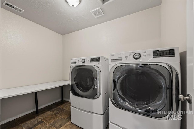 laundry area featuring independent washer and dryer and a textured ceiling