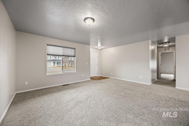 spare room featuring carpet and a textured ceiling