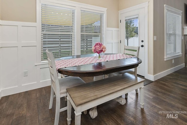 dining area featuring dark wood finished floors and a decorative wall
